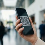 女性手持iPhone，屏幕二维码样式，商务背景虚化